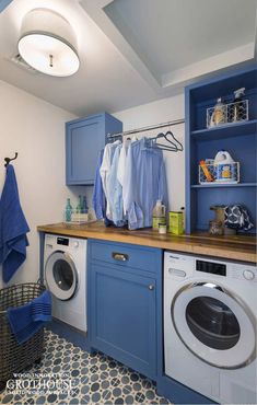 a washer and dryer in a room with blue cabinets