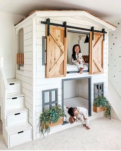 two children are playing in the lofted bunk bed that is made out of wood