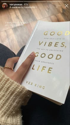 a person holding a book in their hand with the title good vibes, good life written on it