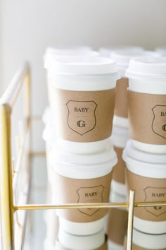 several coffee cups are stacked on top of each other with the label baby gg printed on them