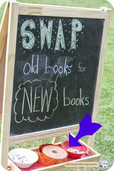 a chalkboard sign with the words swap old books for new books on it in front of some grass