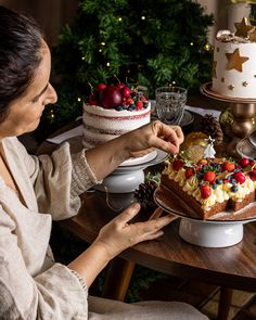 a woman sitting in front of a cake on a table