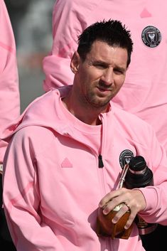 a man in a pink hoodie holding a bottle