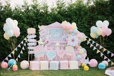 a pink and blue baby shower party with balloons, cake, decorations and other items