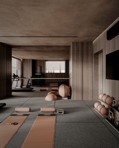 an empty room with yoga mats on the floor and exercise equipment in the back ground