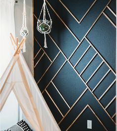 a teepee tent in the corner of a room with black walls and white curtains