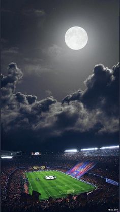 a full moon over a soccer field with clouds in the sky and lights on it