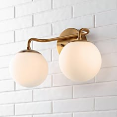 two light fixtures on a white brick wall