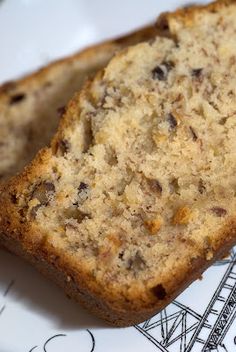 two slices of banana bread sitting on top of a table next to a piece of fruit