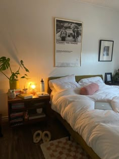 a bed with white sheets and pillows in a bedroom