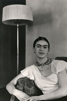 a woman sitting in a chair next to a lamp