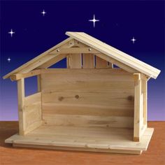 a wooden nativity scene with a baby's crib and stars in the sky