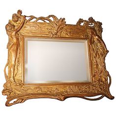 an ornate gold framed mirror with cherubs and flowers on the border, against a white background