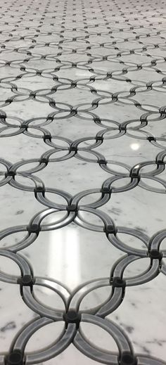 an image of a white marble floor with circles and lines on the tile in front of it