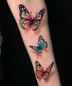 three colorful butterflies on the arm