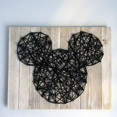 a mickey mouse string art piece on a white wall