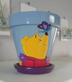 there is a glass cup with a cartoon character on it and a butterfly sitting on top