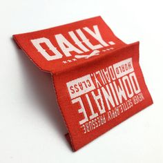 a red tag with white lettering on it that says daily and downhille, against a white background