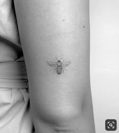 a small bee tattoo on the arm