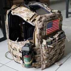 an army backpack with the american flag on it's back and other items inside