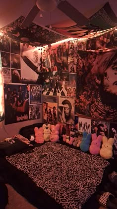 a bed with stuffed animals on it in a room filled with pictures and posters hanging from the ceiling