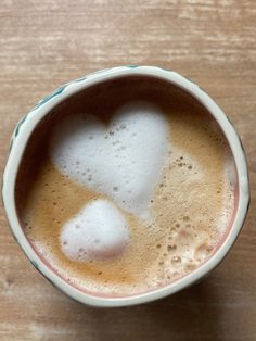 a cup filled with liquid on top of a wooden table