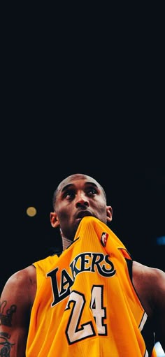 a basketball player holding a jersey in his hand and looking up at the sky with an intense look on his face