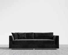 a black couch sitting on top of a white floor