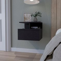 a bedroom with a bed, night stand and lamp on the wall next to it