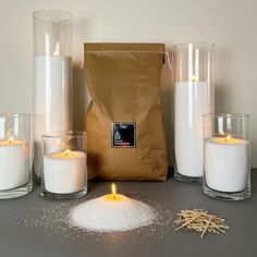 some candles are sitting on a table next to a bag