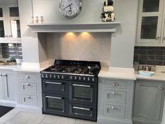 a kitchen with an oven, range and clock on the wall