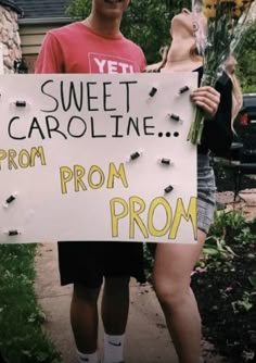 a man holding a sign that says sweet carolina prom prom