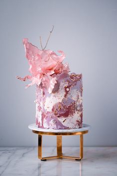 a pink and gold cake on a white plate