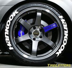 this is a close up view of the wheels on a sports car that has blue and white decals