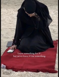 a woman sitting on top of a red blanket