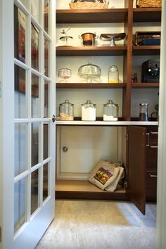 an open pantry with glass doors and shelves