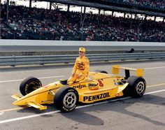 a man sitting on top of a yellow race car