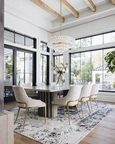 a dining room table with chairs and a chandelier hanging from it's ceiling