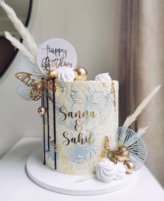 a birthday cake decorated with gold and white decorations