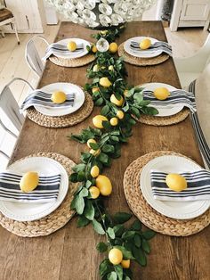 the table is set with plates and place settings for lemons on top of leaves