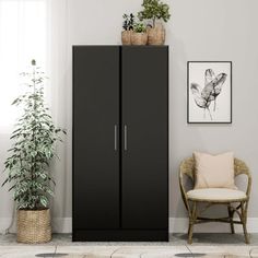 a living room with a chair and a tall black cabinet in the corner next to a potted plant