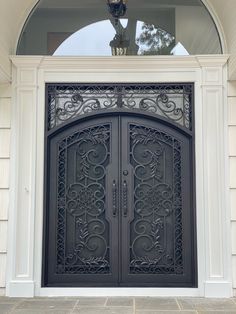 an ornate iron door is shown in front of a house