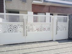 a white gate with laser cut designs on it