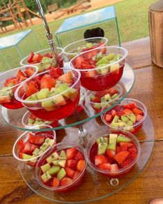 several glasses filled with fruit sitting on top of a table