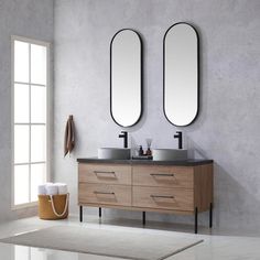 two mirrors are above the double sink vanity in this modern bathroom with concrete walls and flooring