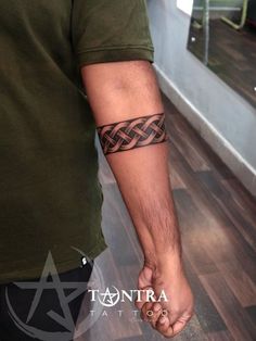 a man with a tattoo on his arm is holding the hand of another person's wrist