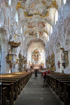 the inside of a church with people standing in it