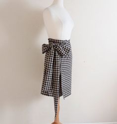 the mannequin is wearing a black and white checkered skirt with a bow