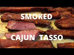 the words smoked cajun taso are in front of some meat