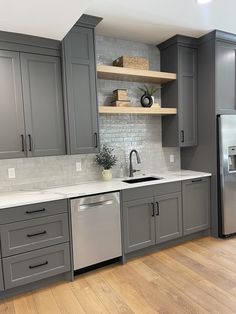 a kitchen with gray cabinets and white counter tops